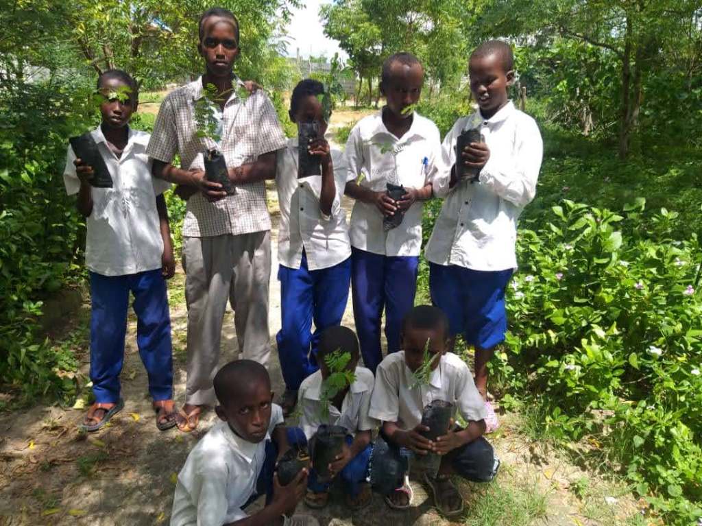 Kuvassa nuoria poikia Somaliassa istuttamassa puuntaimia